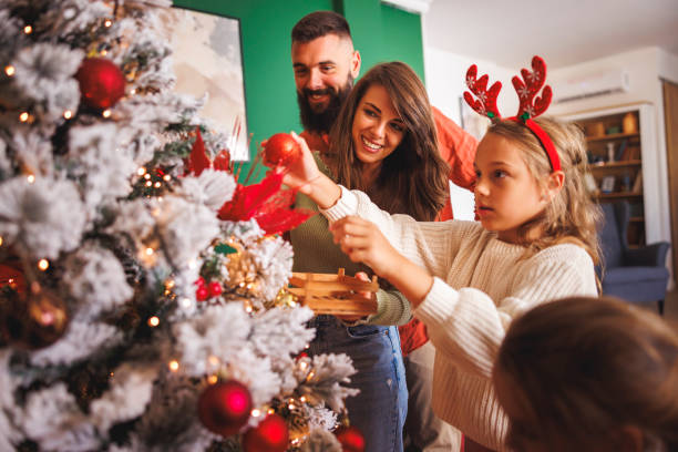istock Parents decorating Christmas tree with children 2178338117