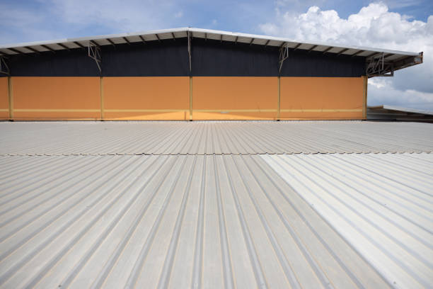 A large building with a white roof and a blue stripe. The roof is made of metal and has a grey color