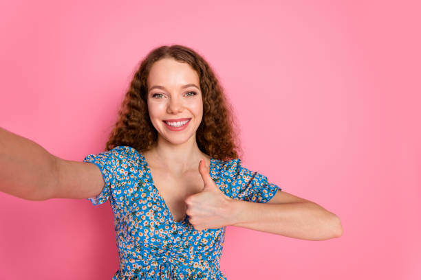istock Smiling woman showing thumbs up on pink background 2178339066