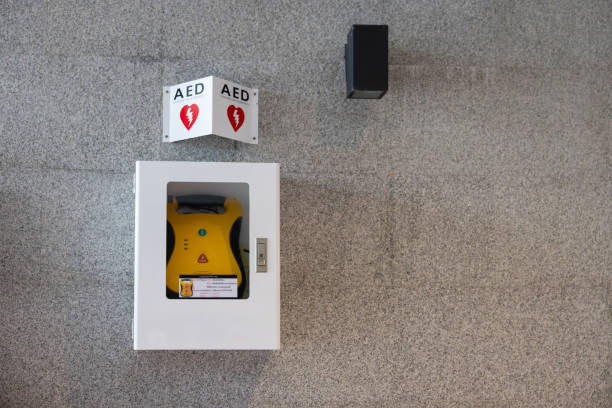 A yellow and red box with the word AED on it. The box is next to a wall