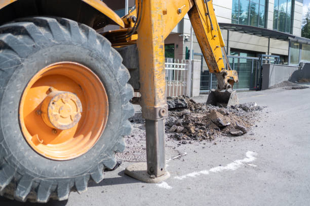Excavator Operator Digging A Hole On Road To Pipeline Replacement On The City Street