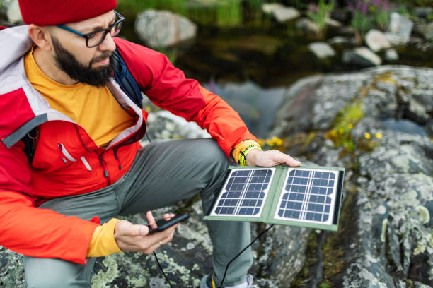 istock Mid adult man hiking with solar panel and charging mobile 2178341861