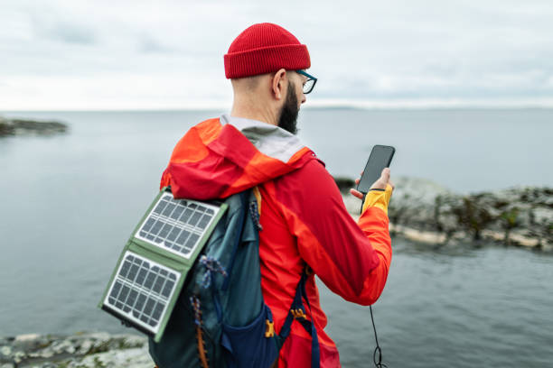istock Mid adult man hiking in mountains with solar panel and charging mobile 2178341862