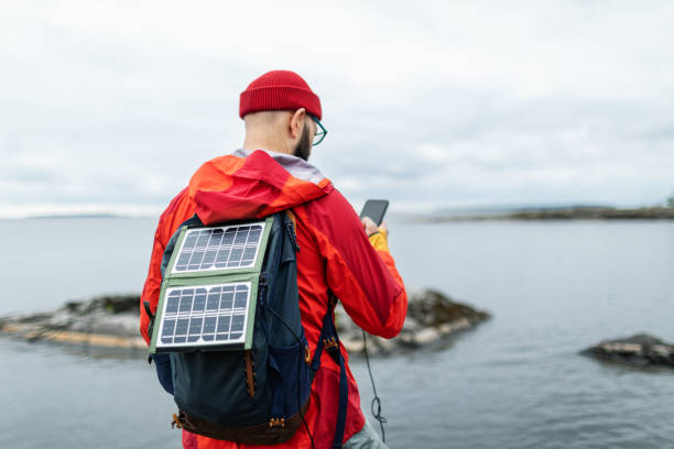 istock Mid adult man hiking in mountains with solar panel and charging mobile 2178341870