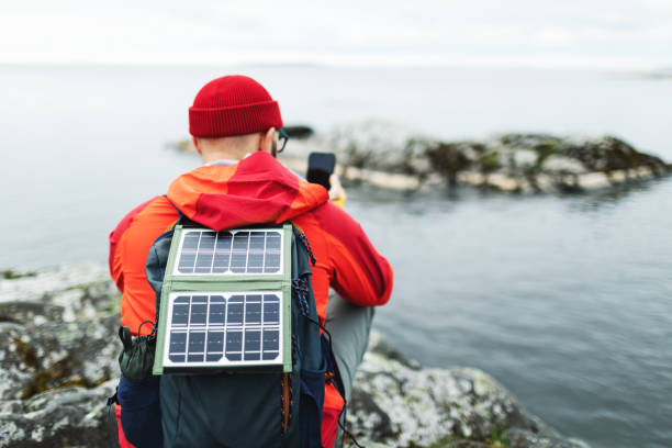 istock Mid adult man hiking in mountains with solar panel and charging mobile 2178341882
