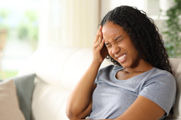 istock Black woman suffering head ache sitting at home 2178341959