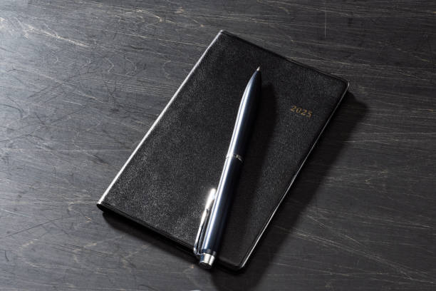 istock 2025 Notebook and pen on wooden table (2025 schedule book) 2178342565