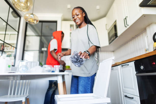 Young adult couple sorting waste at the kitchen