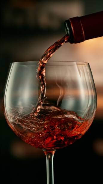istock Close-up of red wine pouring into glass 2178343545