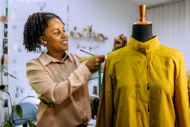 istock Smiling female tailor working at her small clothing store 2178349699