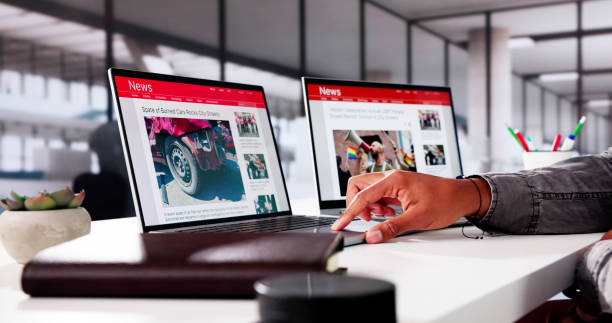 istock Watching Online News Article On Mobile Phone And Laptop 2178351984