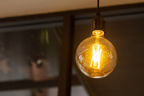 istock A vintage light bulb is lit up and hanging from the ceiling. 2178352496