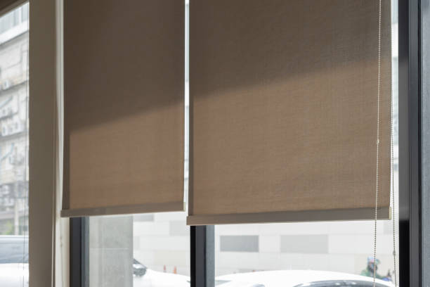 istock Two tan curtains are hanging in a window, letting in some light 2178353533