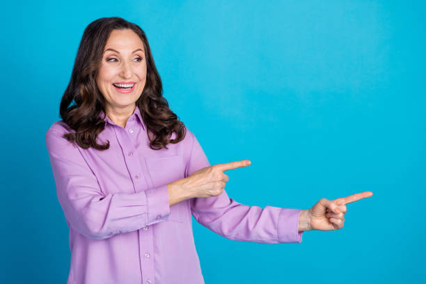istock Photo of cheerful pretty lady dressed puple blouse showing looking empty space isolated blue color background 2178354505