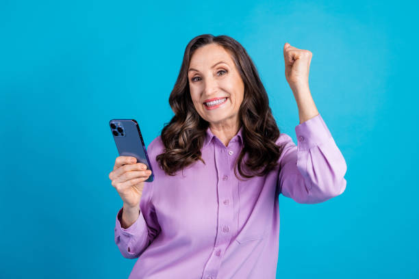 istock Photo of cheerful lucky lady dressed puple blouse winning game modern gadget empty space isolated blue color background 2178354710