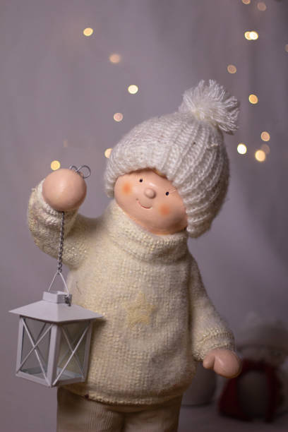 A doll holding a light dressed in all white