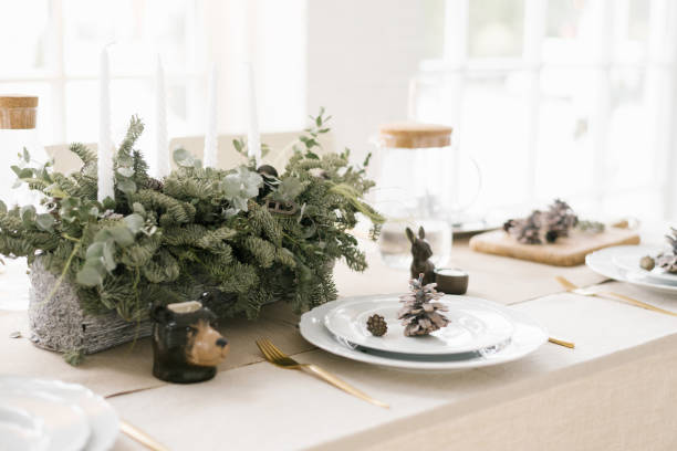 istock Stylish Christmas table setting: a composition of fir branches, white plates decorated with cones 2178365535