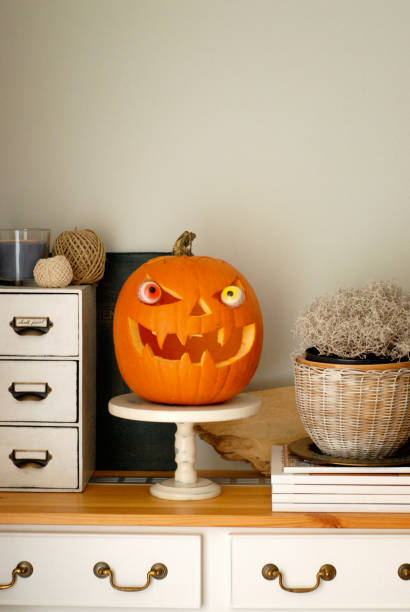 istock Carved Halloween pumpkin with quirky eyes on a home display 2178366058