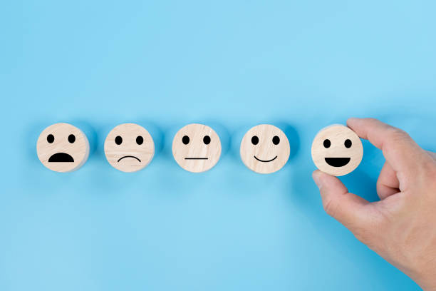 istock Hand holding smile face symbol on wooden cube blocks on blue background. Customer service evaluation 2178366324