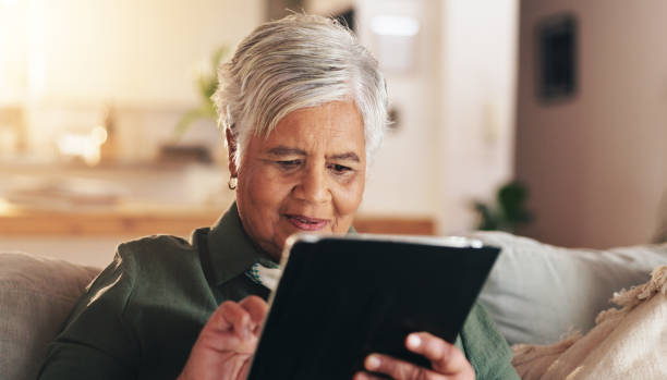 istock Old woman, relax and tablet for communication in home, reading notification and texting on app. Female person, senior lady and couch for scroll on social media, ebook and website for news update 2178366693