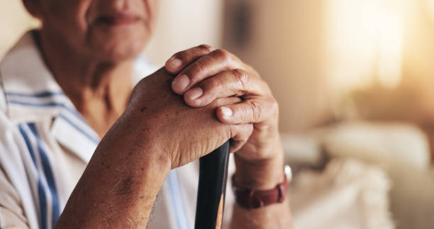 istock Senior, man and hands with walking stick in home for mobility support, alzheimer or rehabilitation. Elderly male, closeup or cane on sofa for balance, dementia or person with disability in retirement 2178366695