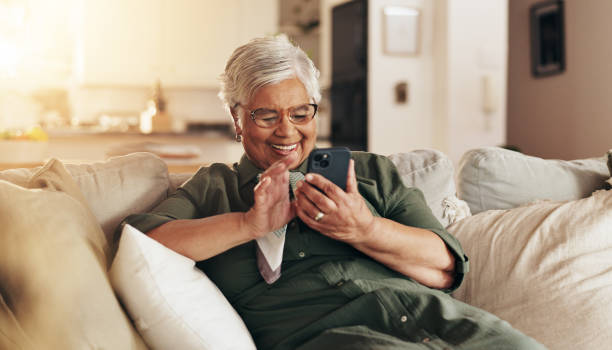 istock Old woman, relax and phone for communication in home, reading notification and texting on app. Female person, senior lady and couch for scroll on social media, funny ebook and website for news update 2178366718