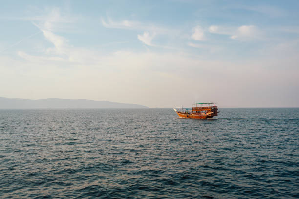 istock Lonely Boat Sailing on Calm Open Sea at Sunset 2178367106