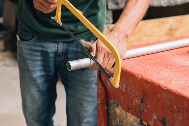 Close up of a person's hands cutting a pipe