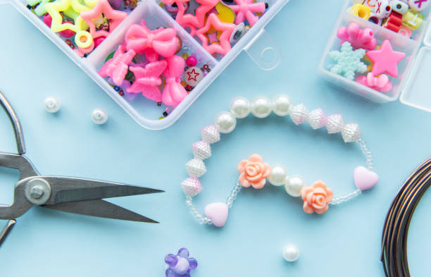 istock Crafting a charming beaded bracelet with colorful resin charms and tools on a light blue workspace 2178369018
