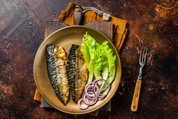 istock Grilled mackerel scomber fish fillets with garnish in a plate. Dark background. Top view 2178369508