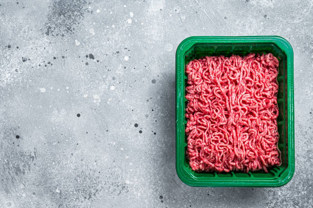 istock Raw Minced Meat in a Plastic Container, ground beef. Gray background. Top view. Space for text 2178369534