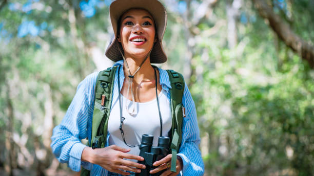 istock Trendy young woman using binoculars in the woods 2178371659