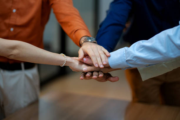 istock Close-up of multiracial business professionals stacking hands in unity, symbolizing teamwork, success, and corporate collaboration. Highlighting diversity, leadership, and mutual support in the workplace, this image captures the essence of corporate. 2178376754