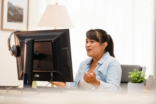 istock Young adult female student gestures while presenting an assignment to her online class 2178381997