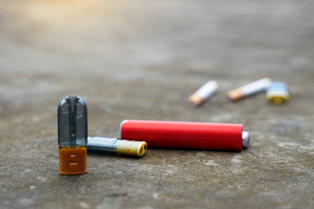 istock Electronic cigarettes on the cement floor and blurred backgrounds of various types of cigarettes, concepts of types of cigarettes, harms and dangers, addictive substances 2178384439