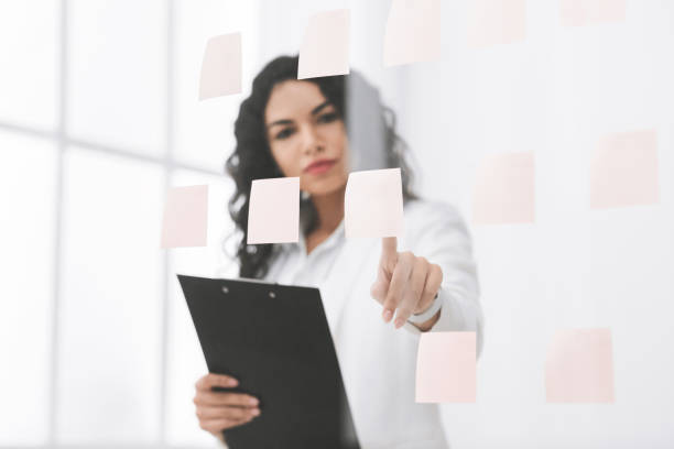 istock Hispanic businesswoman making notes on glass wall 2178386086