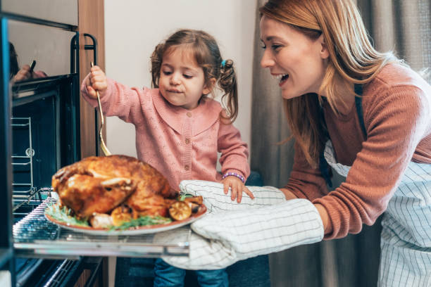 Mother and daughter preparing turkey for Thanksgiving