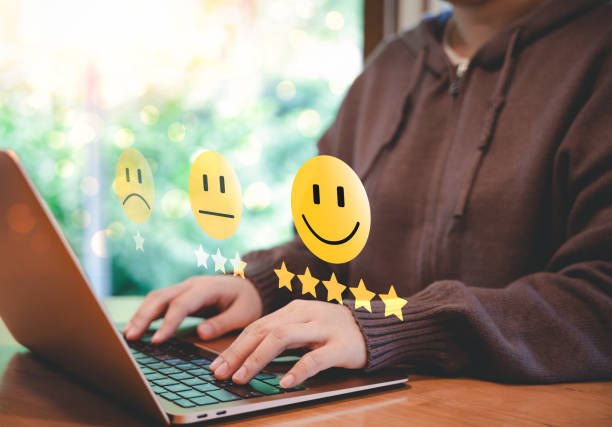 istock Customer satisfaction rating and feedback concept. A person types on laptop, with smile face icons representing different satisfaction levels, customer reviews, feedback, and user experience rating. 2178388858