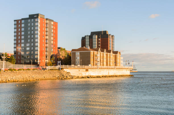 Modern waterfront apartment blocks under clear sky at sunset in autumn. Saint John, NB, Canada.