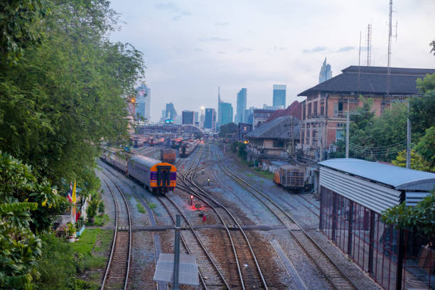 Hua Lamphong train  station and railway tracks in Bangkok in sunset light, View from bridge at Bamrung Mueang Road. On tracks several old trains are parked. Behind is modern skyline of Sampheng to Sathorn.