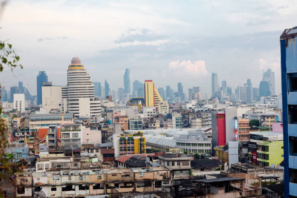 Wat Phra Kaew and Wat Pho in left area  seen from high angle view and rooftop position in Bangok Chinatown and Phra Nakhon. Wat Phra Kaew buildings and temples are in center of middle horizon. In foreground are old buildings of Chinatown