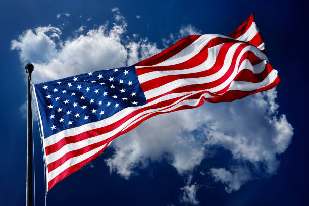 istock American flag on blue sky with beautiful clouds 2178393653