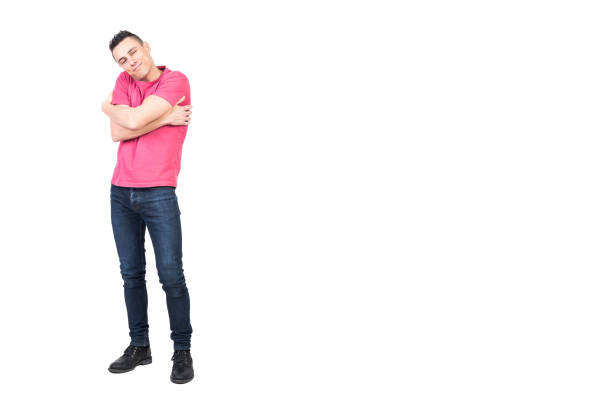 Merry male in casual clothes embracing shoulders and looking at camera with smile while expressing love isolated on white background