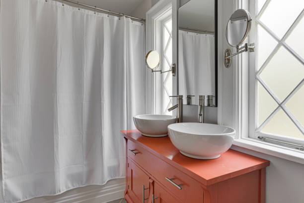 Closed metal faucet on a cream-colored bathroom sink near toiletries, water use and hygiene theme
