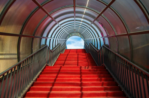 Red staircase with arched roof. Ascending forward to the sky. Modern architecture concept