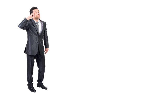 Full body of funny clever male entrepreneur in formal suit touching head and looking at camera against white background