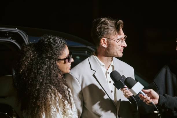 istock Male Celebrity with Young Woman Interviewed by Press Outdoors at Night 2178408040