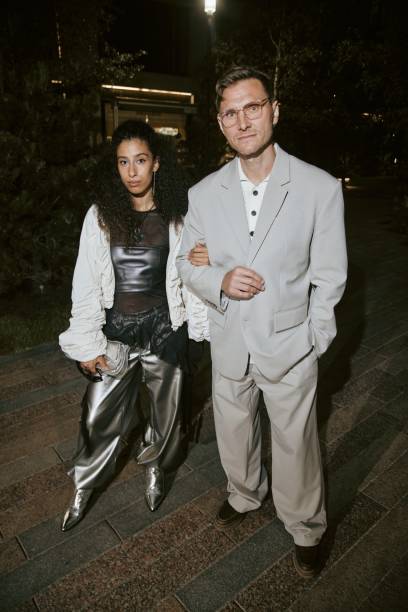 istock Female Celebrity in Silver Pants Standing with Man in Gray Suit while Posing for Paparazzi 2178408042