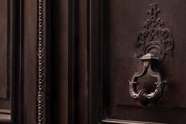 An Elegant and Stylish Antique Door Knocker Set Against a Dark Wooden Door Frame