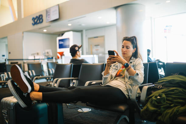 istock Woman browsing through smartphone apps while waiting at the airport gate 2178414013